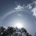 rainbow appearing in the sky around the sun