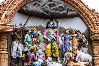 Krishna holding the mountain above his devotees, to protect them