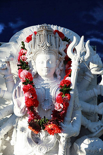 White statue of goddess Durga with red flower garland around her neck