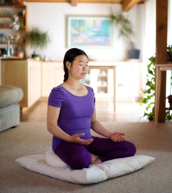 Young lady meditating on a cushion