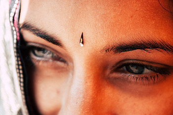 close up of woman with decoration between her eyebrows.